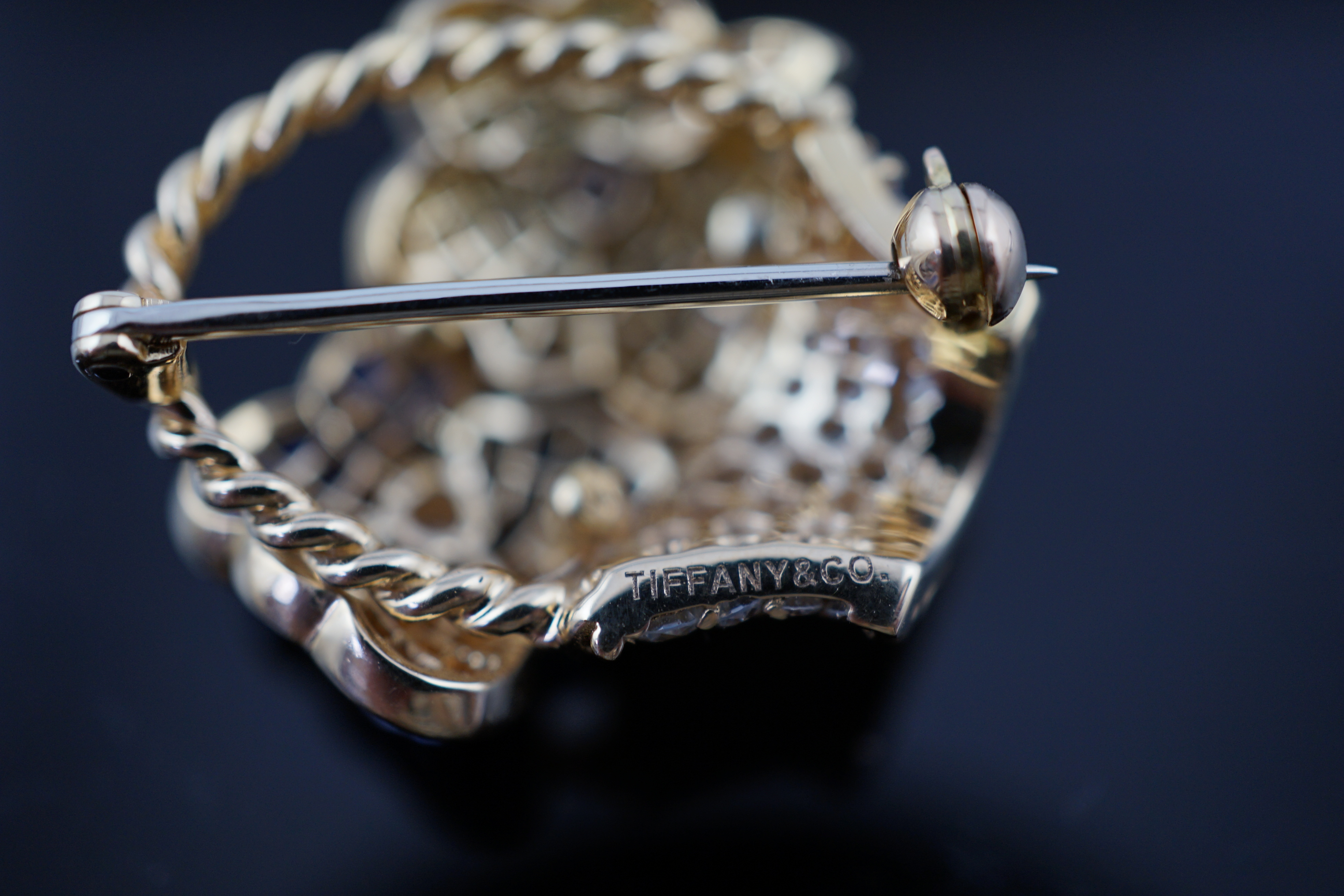 A Tiffany & Co 18k gold, two colour sapphire and diamond cluster set brooch, modelled as a basket with two flower heads